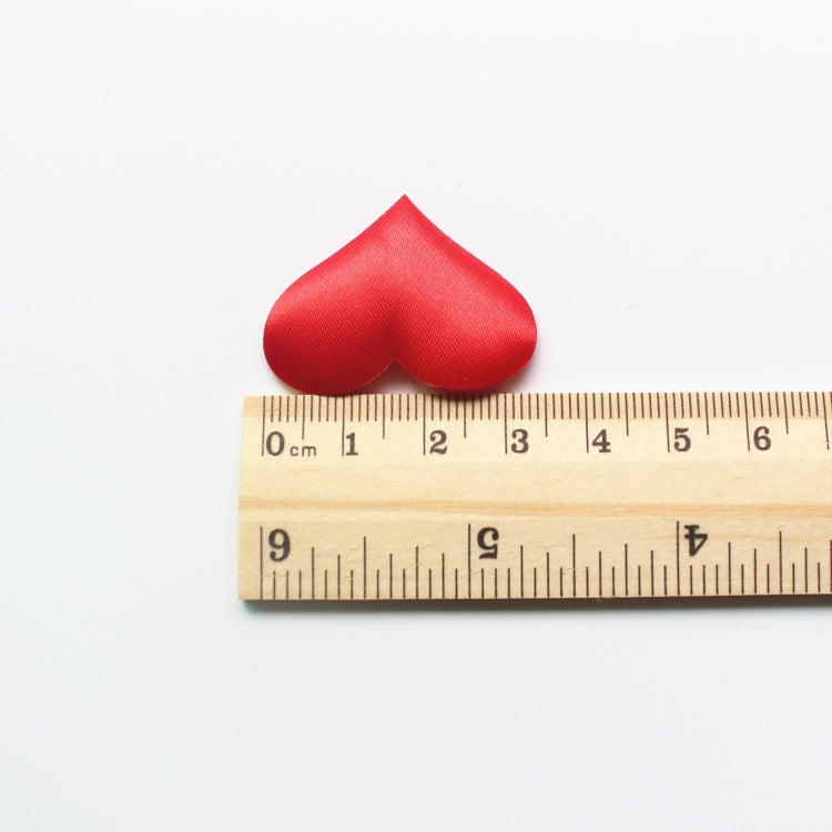 Single red heart-shaped fake petal with a ruler for size reference