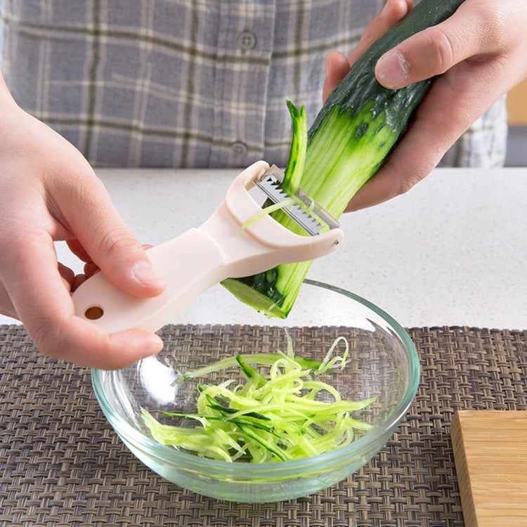 Vegetable peeler shaving celery into a bowl; light blue handle and blades