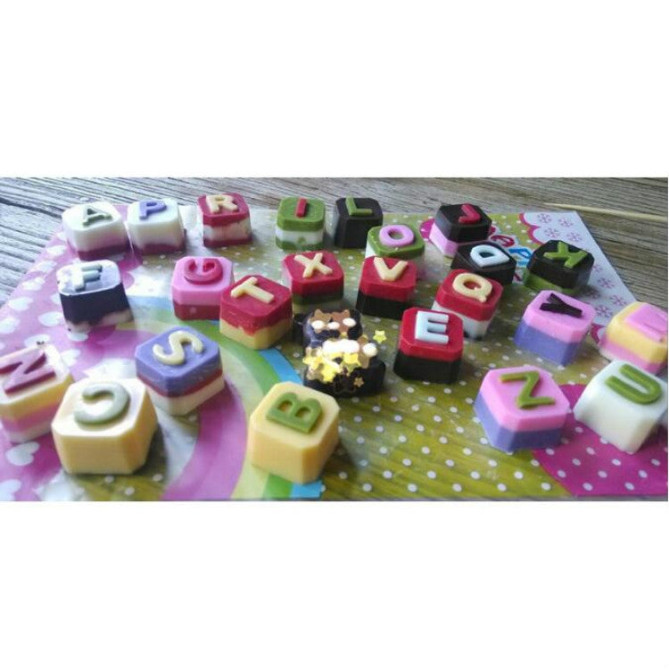 Colorful letter-shaped candy blocks on a tray, made from silicone alphabet molds