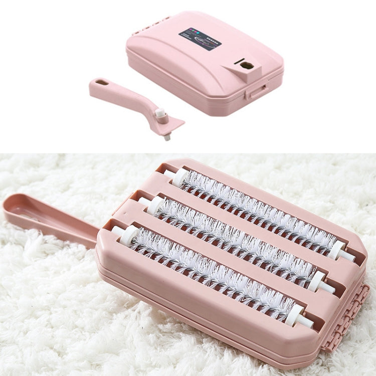 Handheld carpet sweeper brush in pink with roller brush head and side attachment.