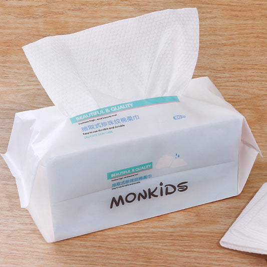 White disposable cotton face towels with textured pearl pattern, in open pack
