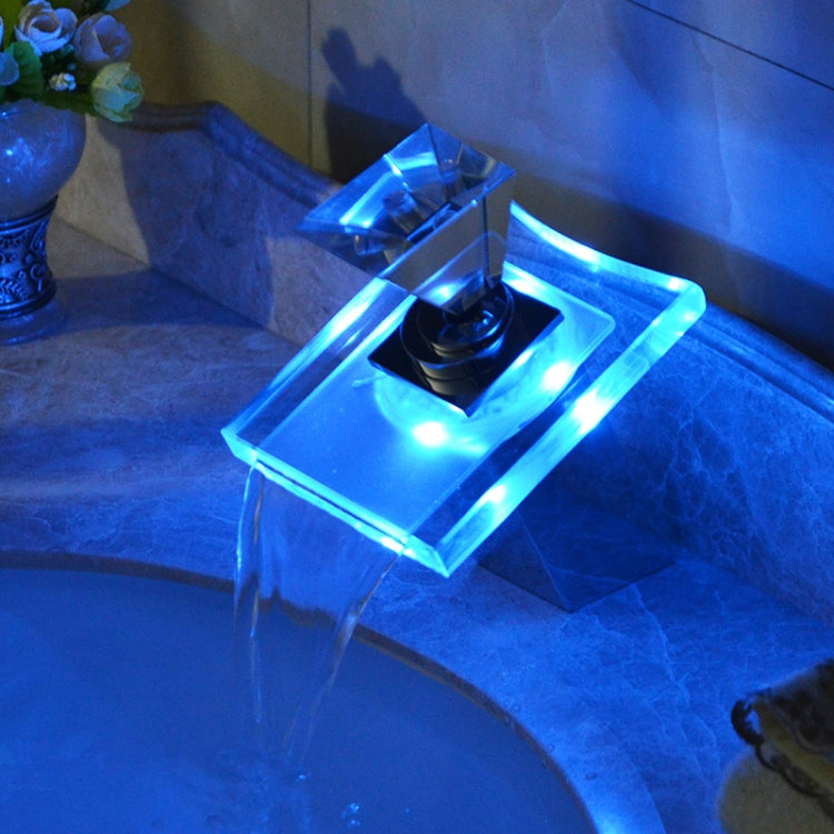 Color-changing LED waterfall faucet with blue illuminated glow and cascading water stream.