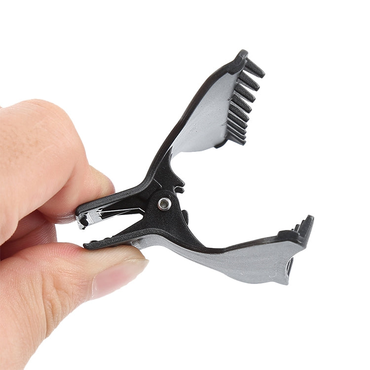 Black butterfly hair clip close-up with teeth and locking spring mechanism