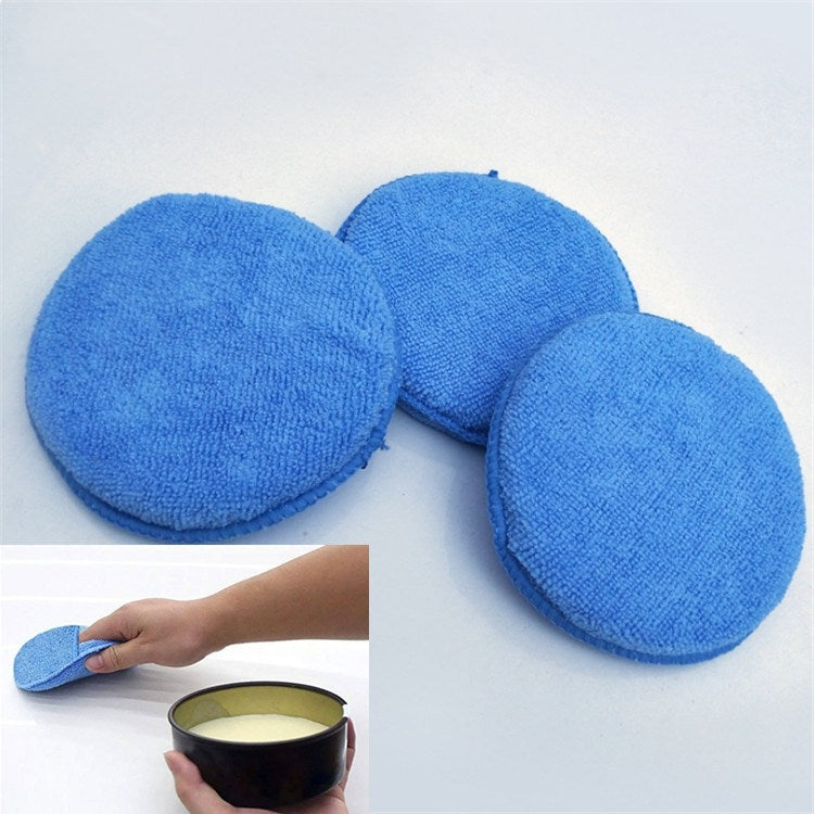 Blue round microfiber waxing sponges, three pads laid flat