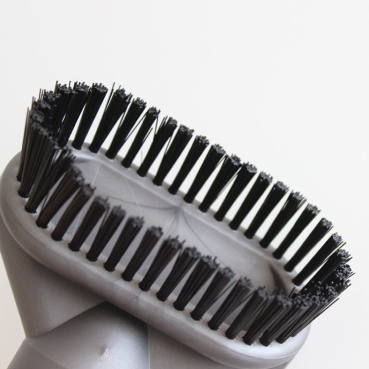 Close-up dust brush head with black bristles on gray housing and visible molded grooves