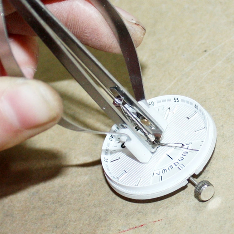 Watch pointer remover tool in use removing a pin from a watch dial