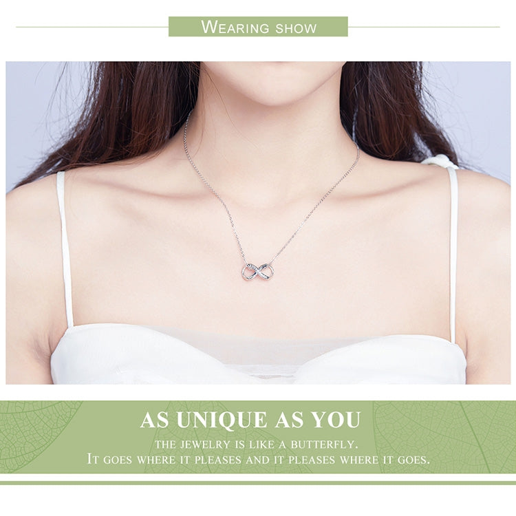 Sterling silver infinity bracelet worn on a neckline with a small infinity charm