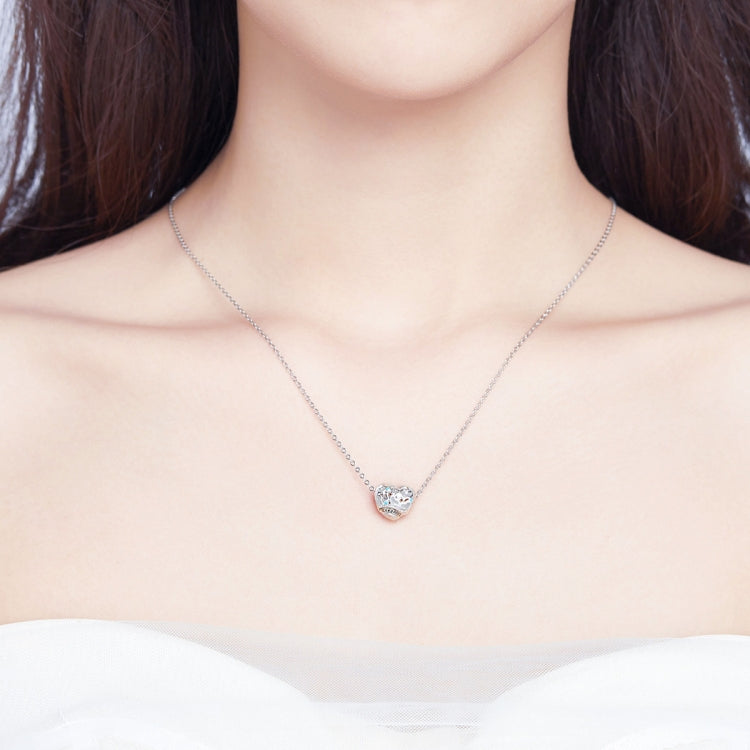 Small silver heart pendant with clear stone center on fine chain