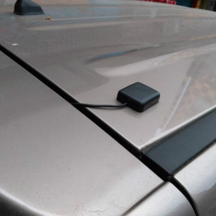 Car GPS signal amplifier antenna puck on vehicle roof with attached cable