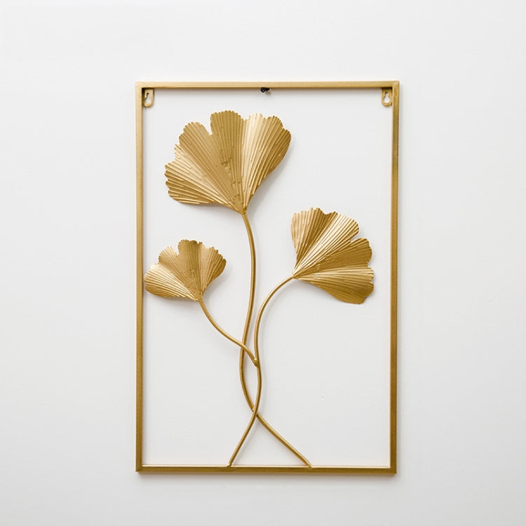 Gold metal leaf wall hanging in a square frame with three ginkgo-style leaves