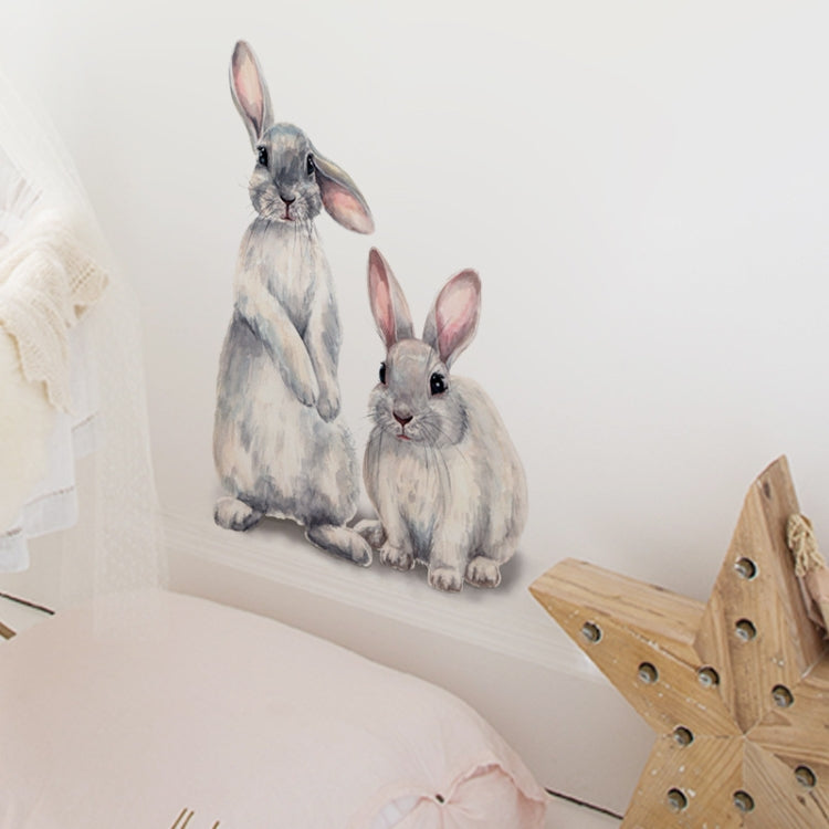 Two rabbit wall sticker figures, gray bunny and white bunny sitting on a wall ledge