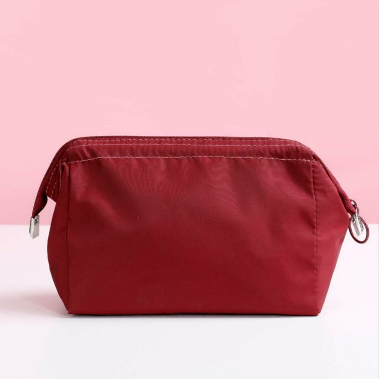 Waterproof cosmetic bag in wine red with zip closure and metal ring pulls