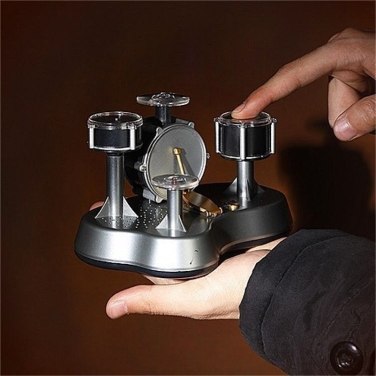 Mini finger drum set in use with hand pressing the small drum pads