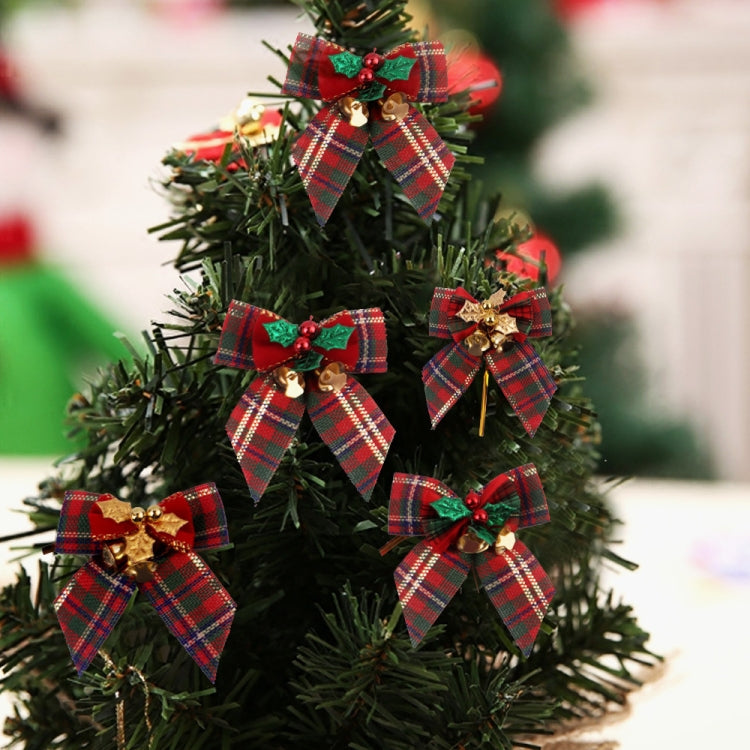 Christmas tree decorations featuring plaid bow ornaments with green holly and gold bells
