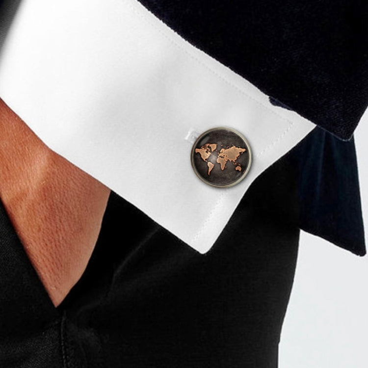 Round world map cufflink on white shirt cuff, black face with bronze continents