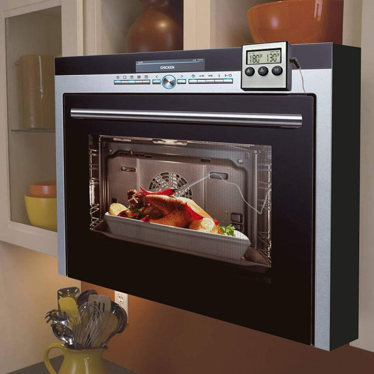 Digital oven probe thermometer attached outside oven door with metal food probe