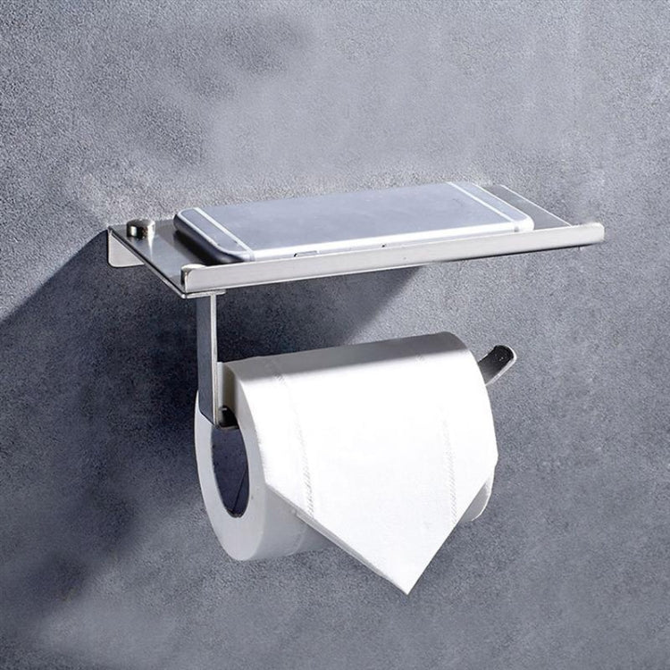Stainless steel toilet paper holder with phone storage shelf and paper roll mounted on wall