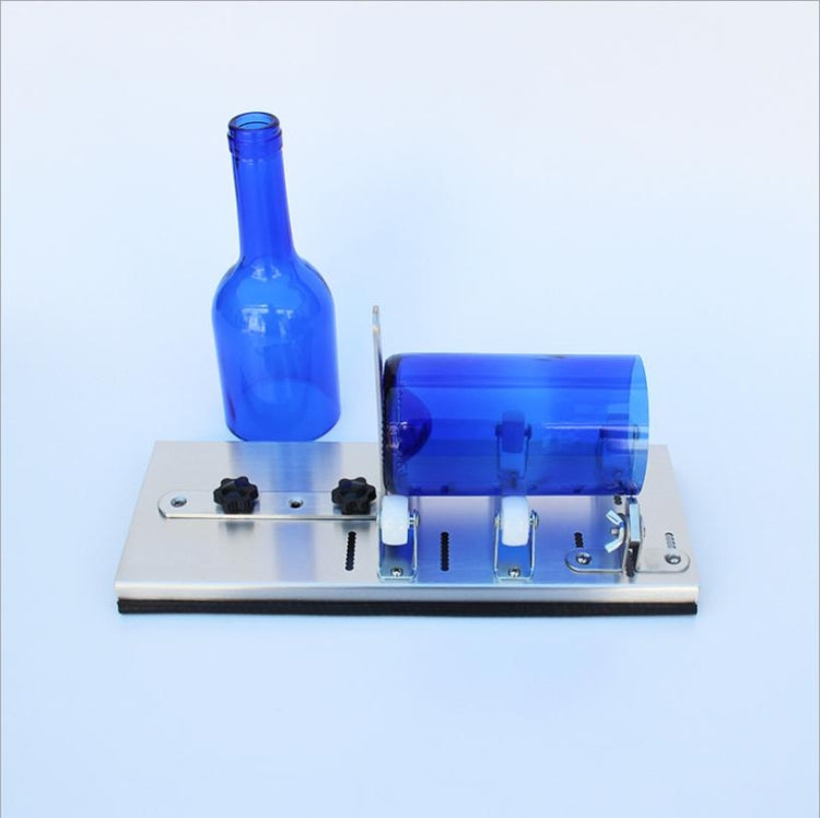 Glass bottle cutter with metal base and blue bottle held in place by clamps