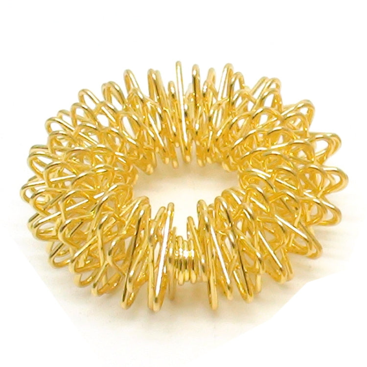 Gold-tone finger massage ring with raised spring bristles close-up
