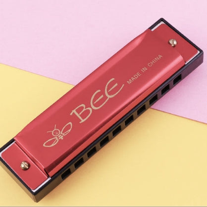 Red 10-hole C-tone harmonica with BEE logo and black row of tone holes