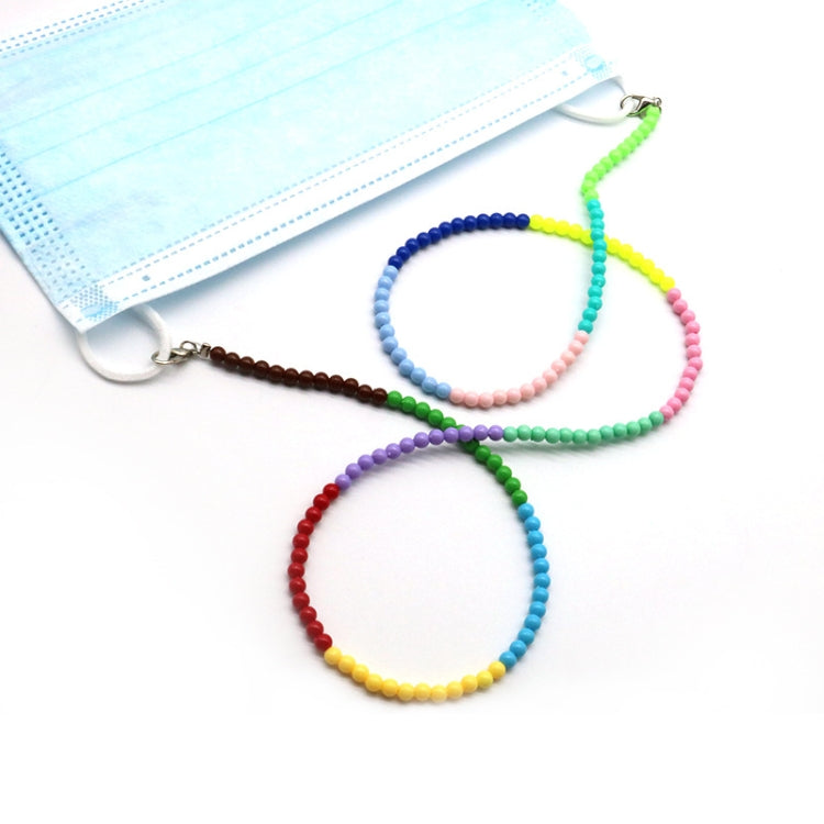 Multicolor beaded lanyard chain with metal clips beside a light blue face mask