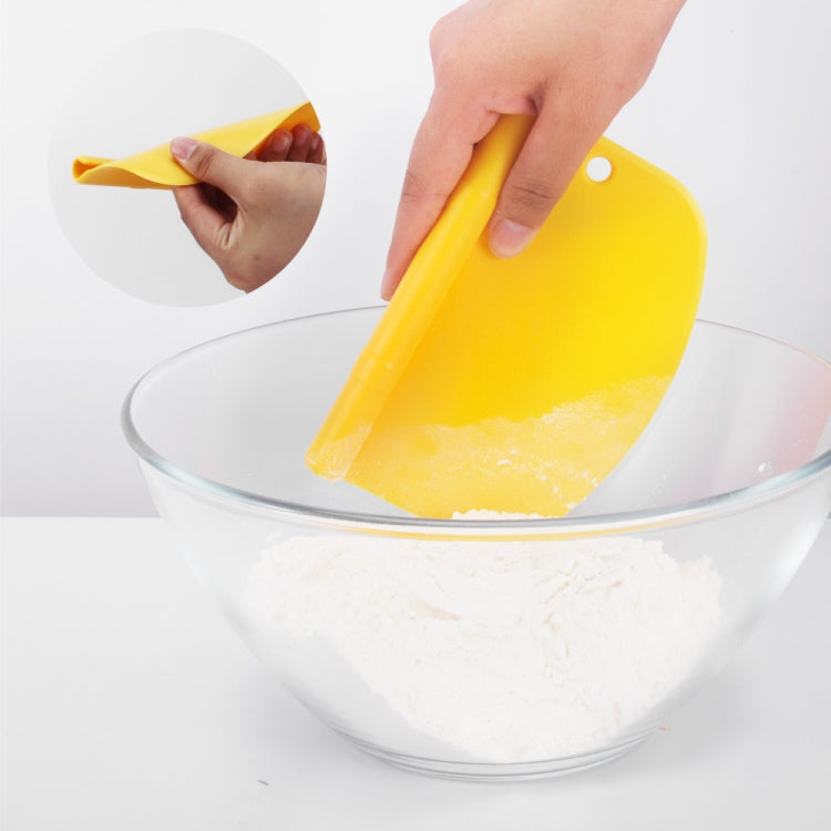 Yellow dough cutter scraping batter into bowl, with roller for cutting.