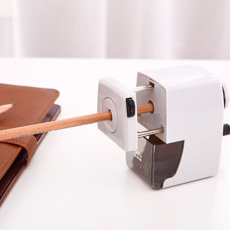 Black and white manual pencil sharpener on desk with pencil inserted