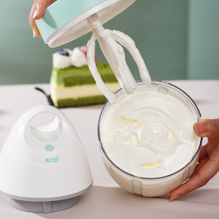 Electric whisk mixer pouring cream into clear container, mint and white base