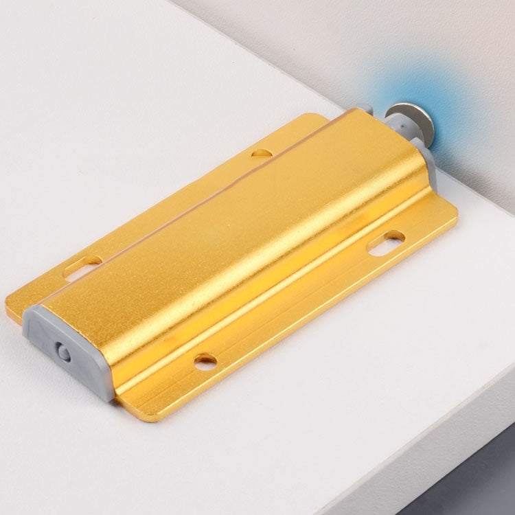 Gold cabinet door bouncer mounted on cabinet edge with metal bracket