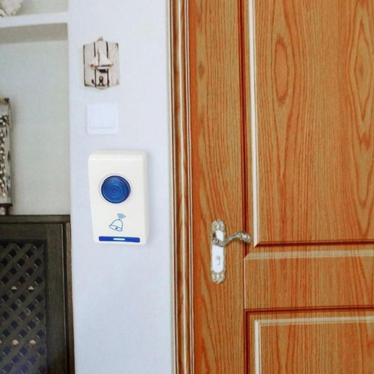 Wireless doorbell receiver and remote mounted near a wooden door and frame.