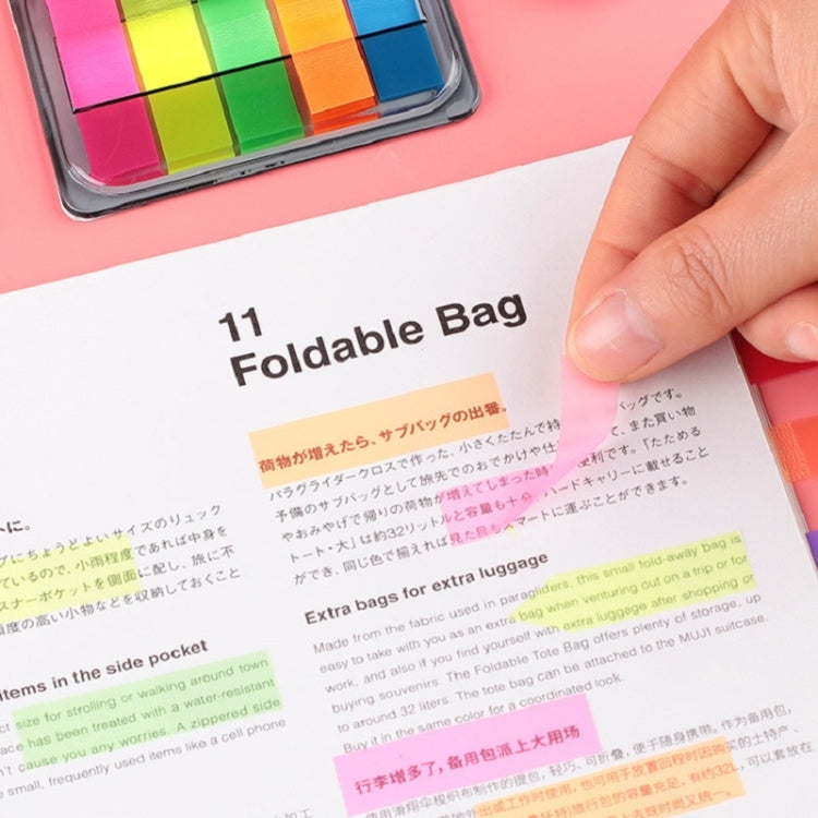 Transparent fluorescent sticky note label on printed page with highlighted text, hand holding
