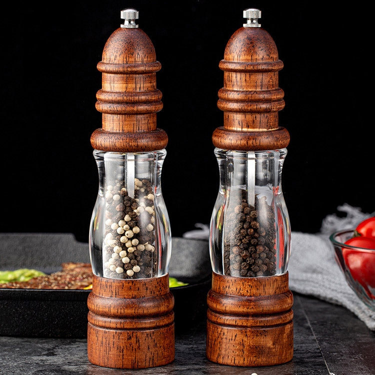 Set of two wooden lighthouse-shaped manual pepper grinders with clear glass chambers