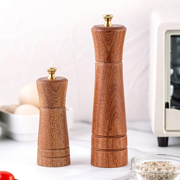 Two wood pepper grinders with brass tops, tall and small carved dark brown wooden bodies