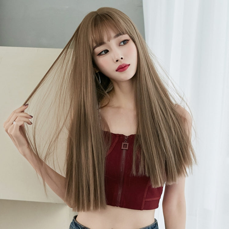Light brown long straight wig with blunt bangs draped over shoulders on model