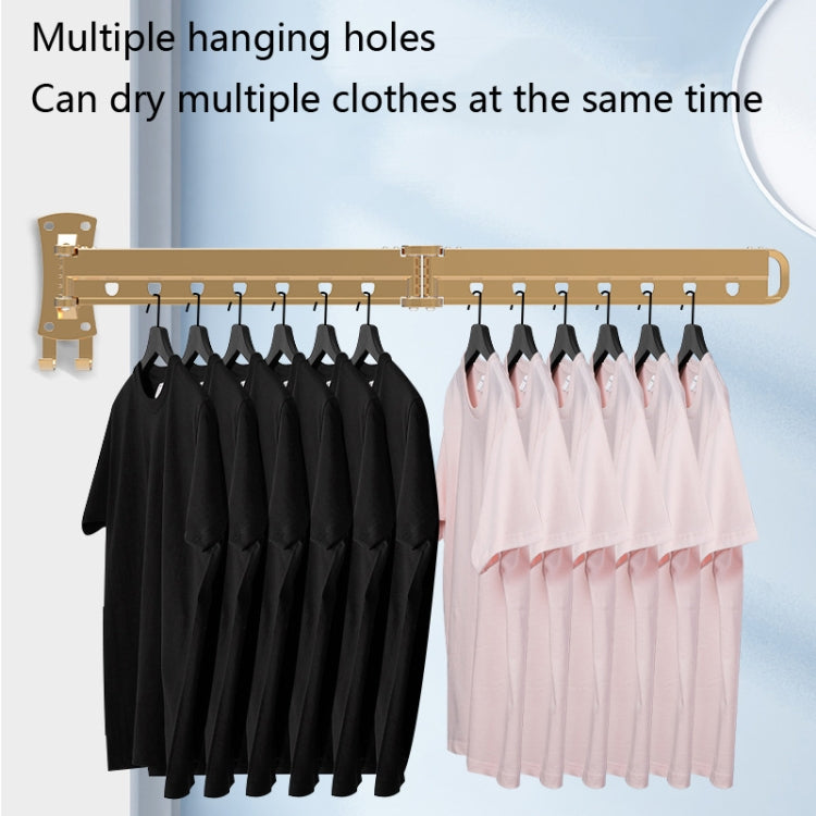 Wall-mounted folding clothes drying rack with multiple hanging holes, holding black and light shirts