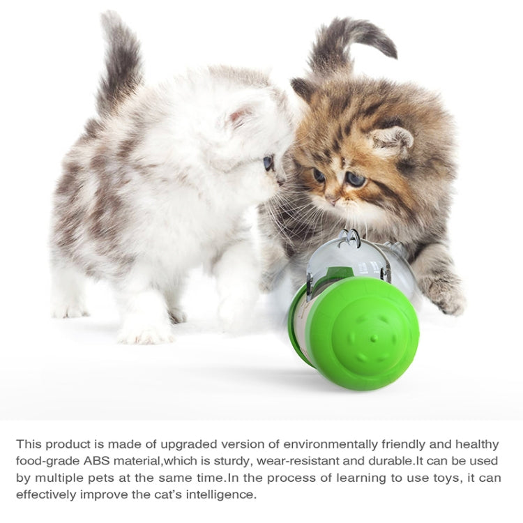 Green and white food-dispensing pet toy with clear window, held by kittens