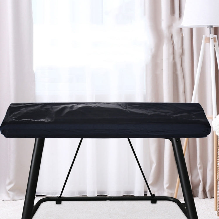 Black keyboard dust cover over electronic keyboard on stand
