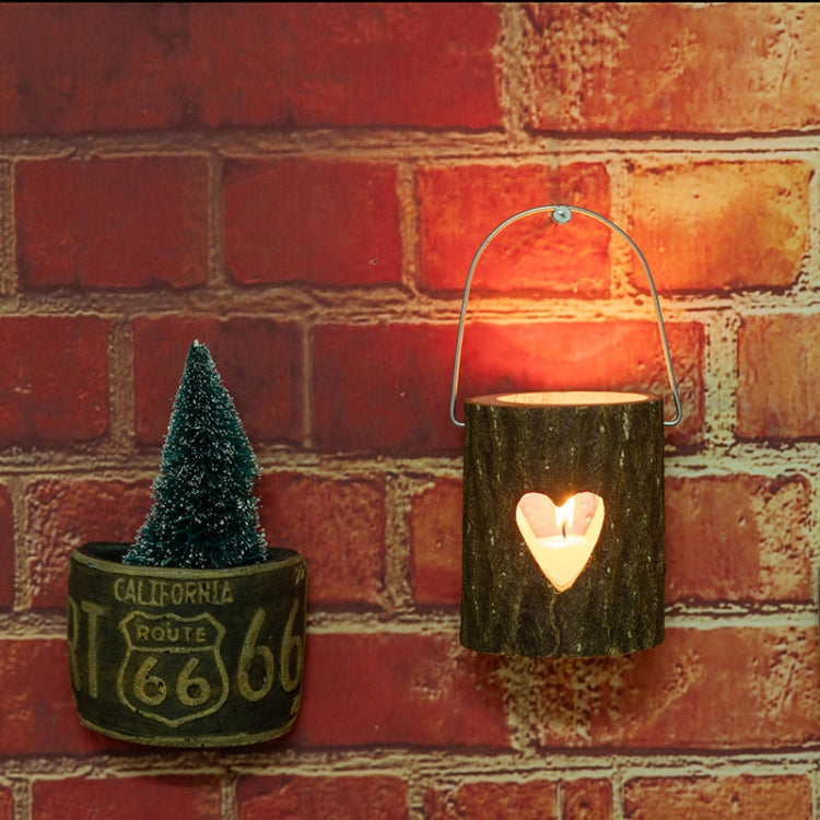 Wooden candle holder with metal handle, lit candle in heart cutout