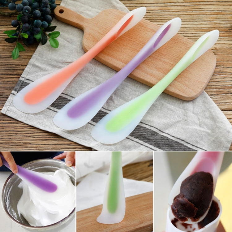 Assorted translucent silicone dual-headed spoon spatulas on cloth and wooden board