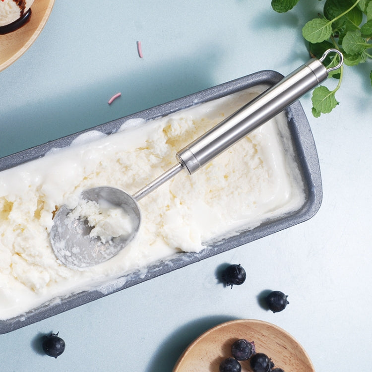 Stainless steel ice cream scoop lifting a scoop from a loaf pan of ice cream
