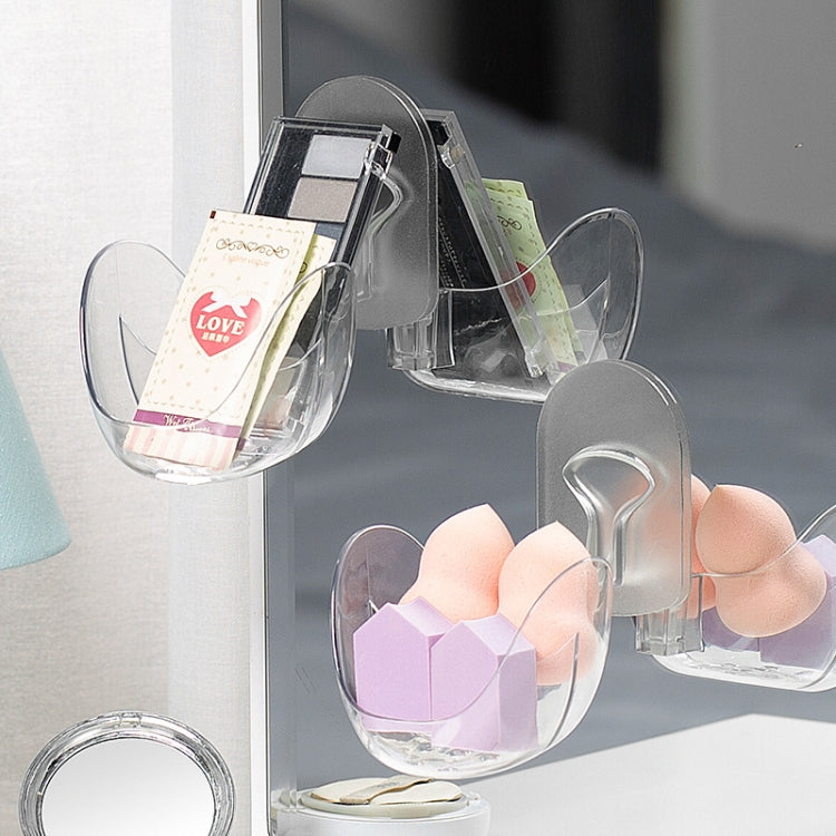 Set of transparent egg-shaped drying racks on hooks, holding sponges and packets
