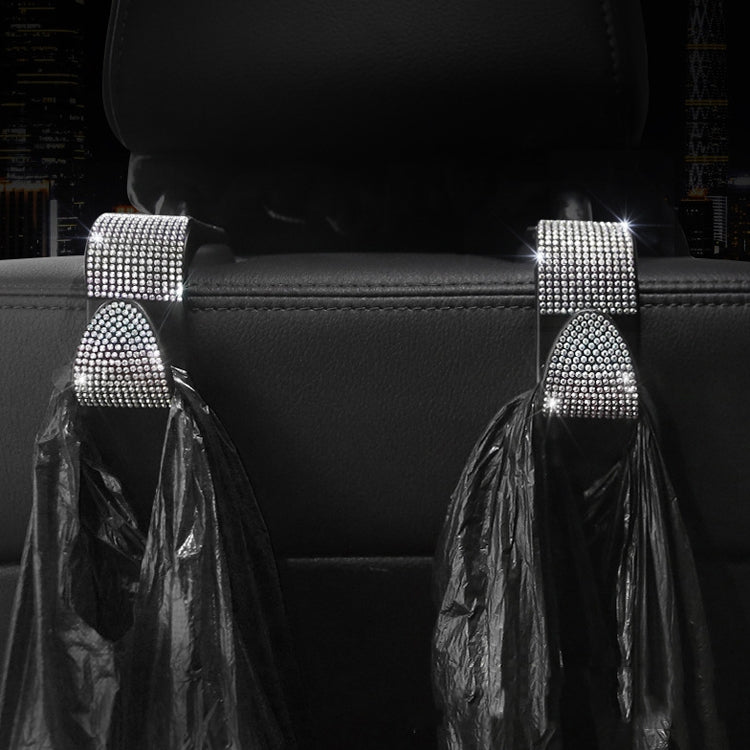 White diamond-studded car rear seat hooks with hanging bag holders