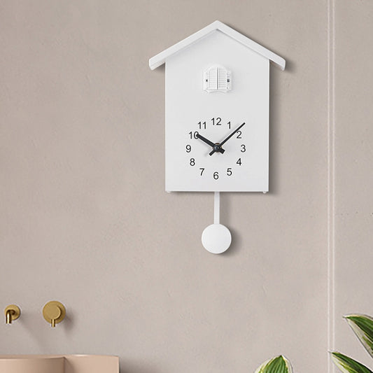 White cuckoo wall clock with pendulum weight and bird compartment on the top