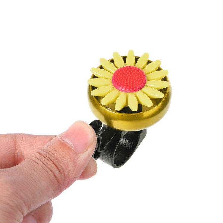 Yellow flower bicycle bell with textured red center being held by a hand