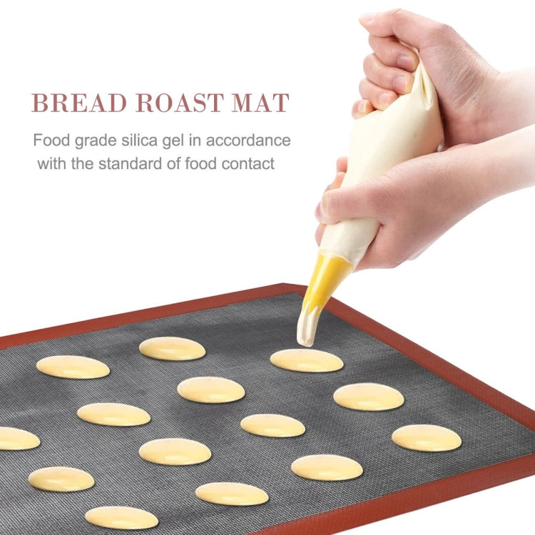 Gray baking mat with orange border on which dough rounds are piped and arranged.