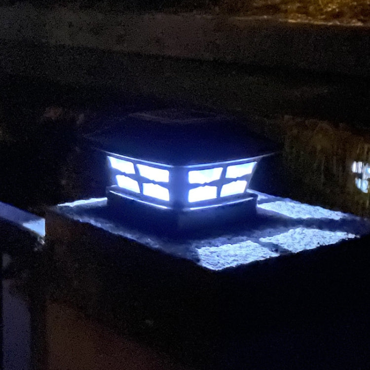 Solar garden column lamp glowing with blue-toned light at night