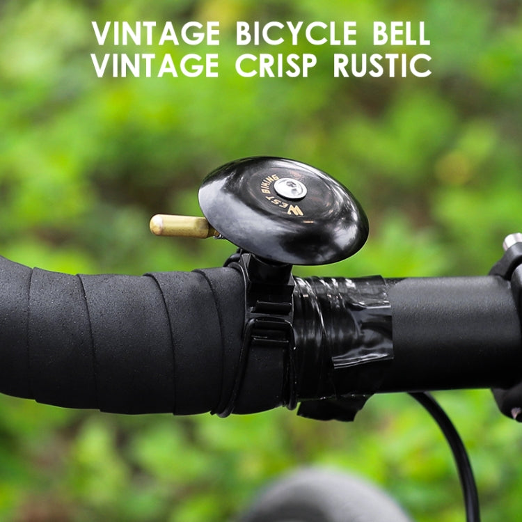 Black bicycle bell mounted on handlebars with gold lever