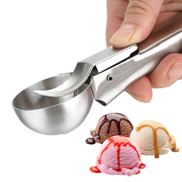 Stainless steel ice cream scoop spoon held in hand beside scooped dessert