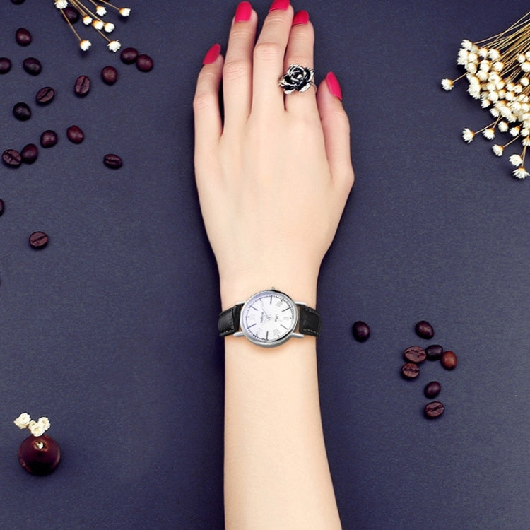 Ladies quartz watch worn on wrist with white dial and dark leather strap