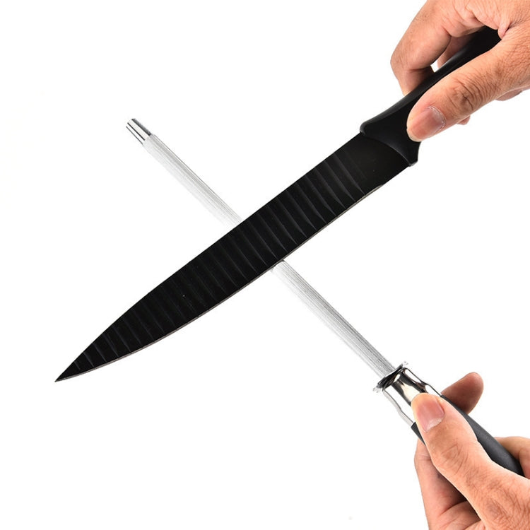 Kitchen sharpening rod with black textured handle and stainless shaft held in hand